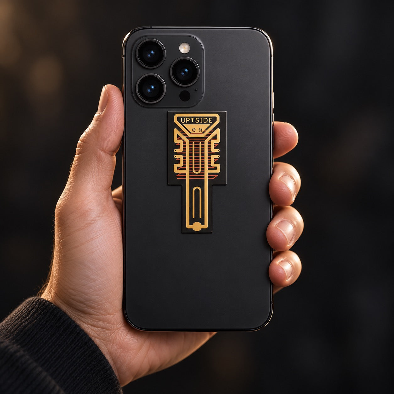Hand holding a phone with the signal booster attachment on its back