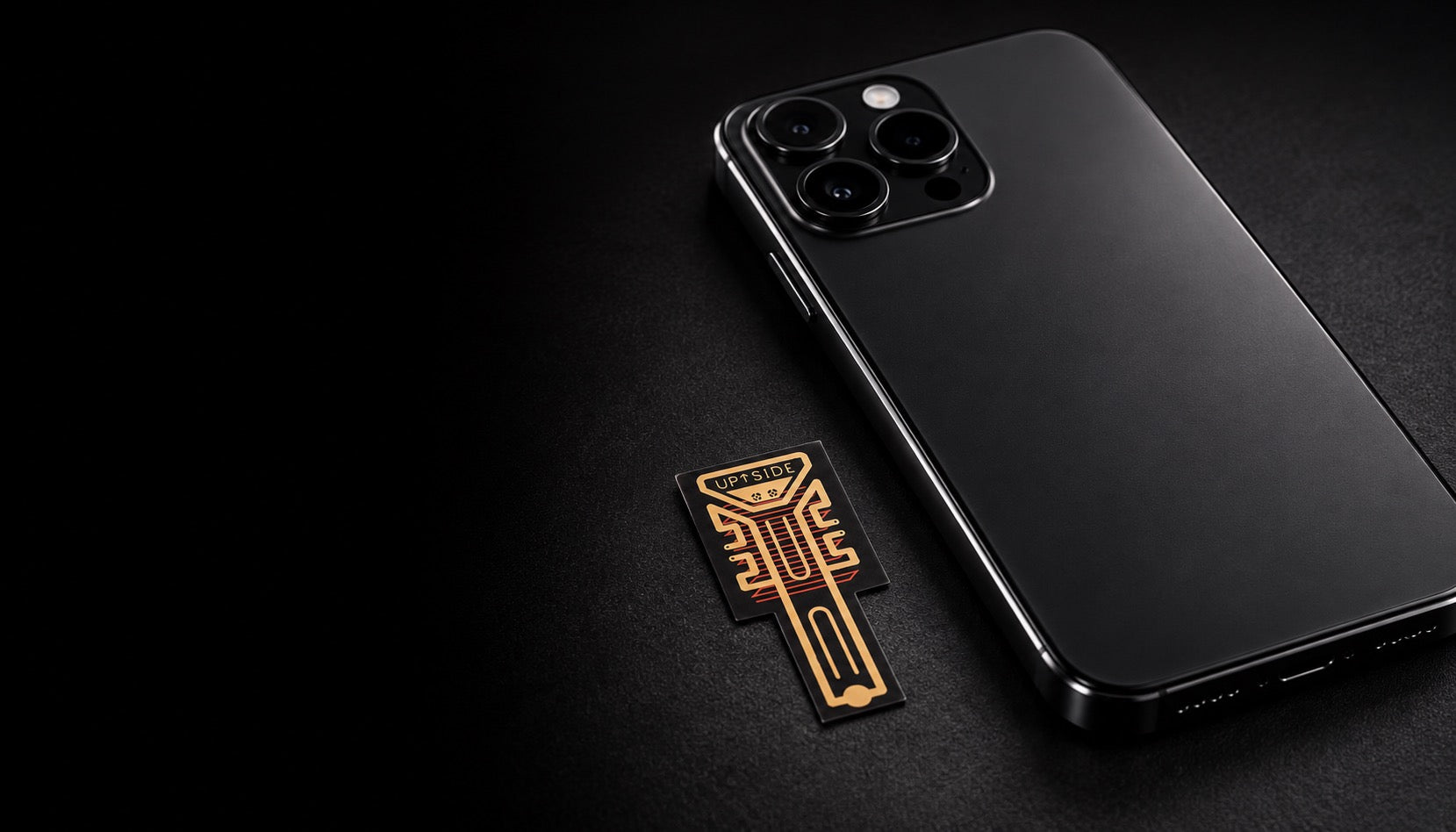Up Side Signal Booster attachment beside a black smartphone